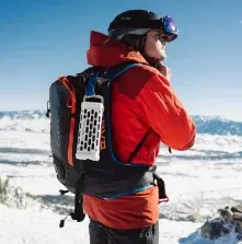 This image shows a person wearing a red and black backpack on a beach with mountains in the background. This is not related.